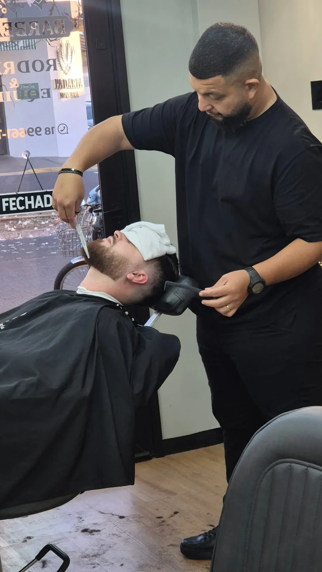Barbeiro cuidando da barba de cliente